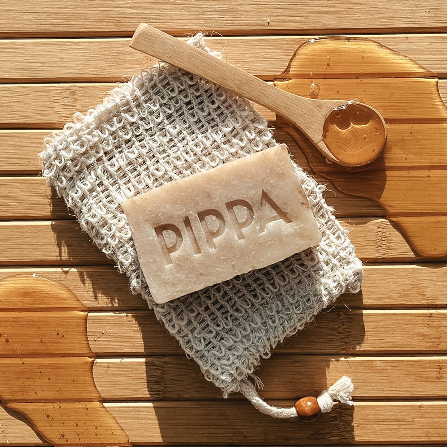 pippa hondenshampo honey en propolis ligt op het sisal zeepzakje op tafel met een lepel met honing