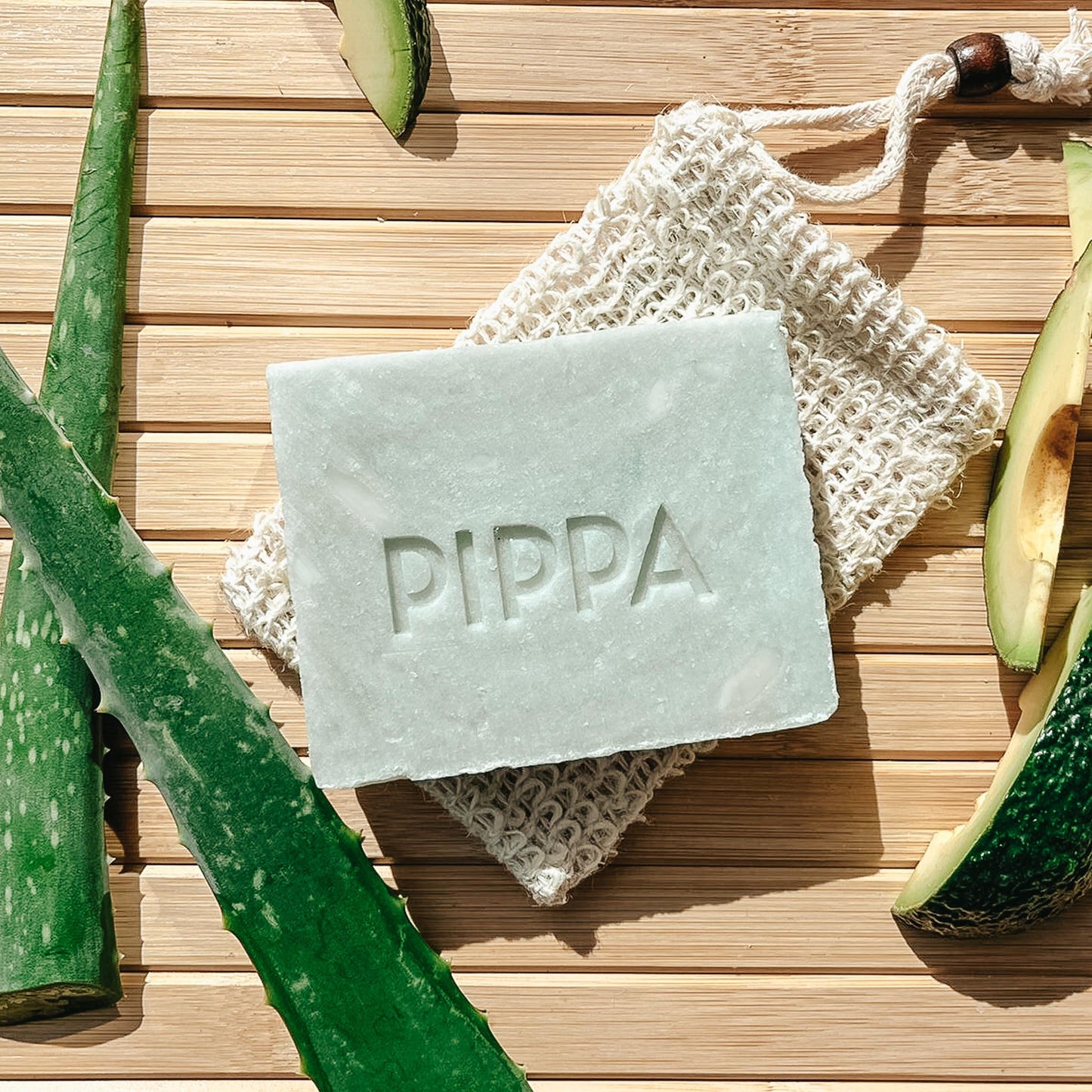 pippa paardenshampoo aloe vera en avocado shampoobar op tafel met het sisal zeepzakje en de ingredienten