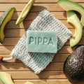 pippa hondenshampoo aloe vera en avocado shampoobar op tafel met het sisal zeepzakje en een avocado