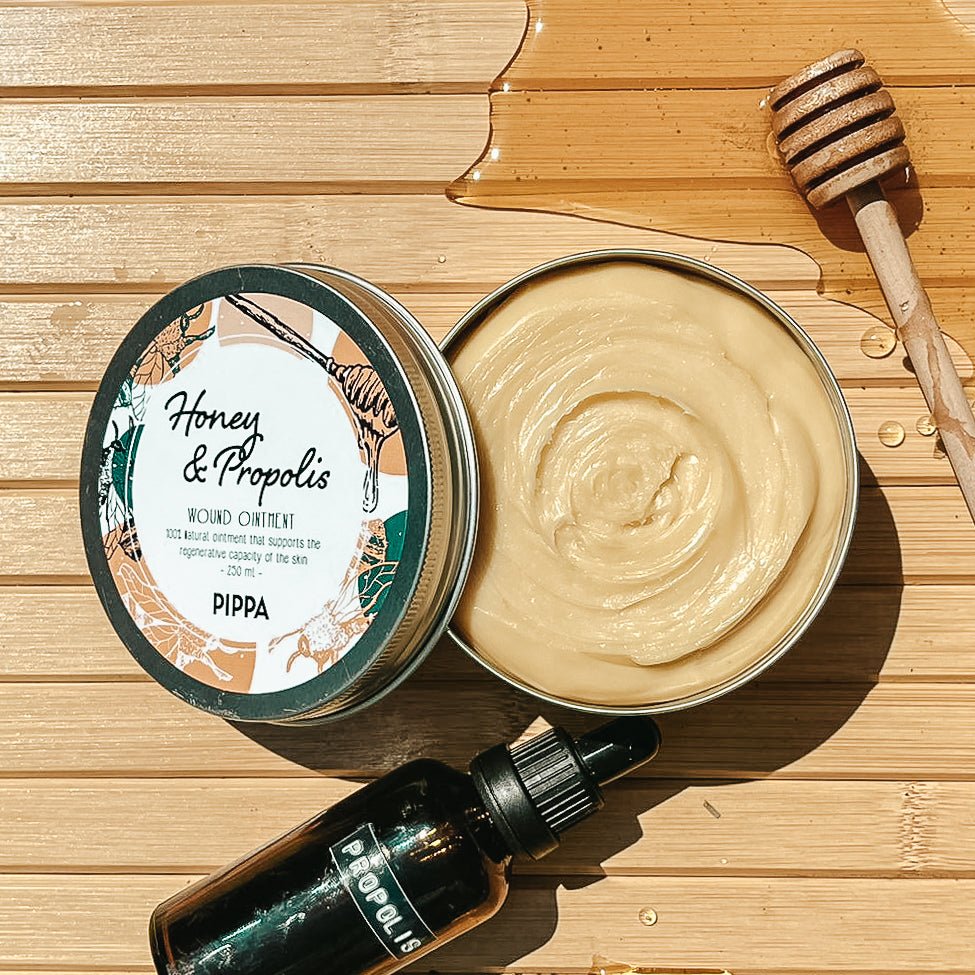 pippa honey propolis honingzalf verpakking ligt op tafel met een honinglepel en een flesje propolis