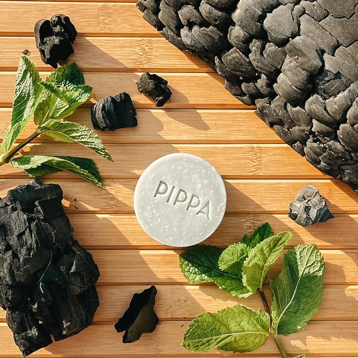 pippa verfrissende body bar charcoal en mint ligt op tafel met de ingredienten er bij